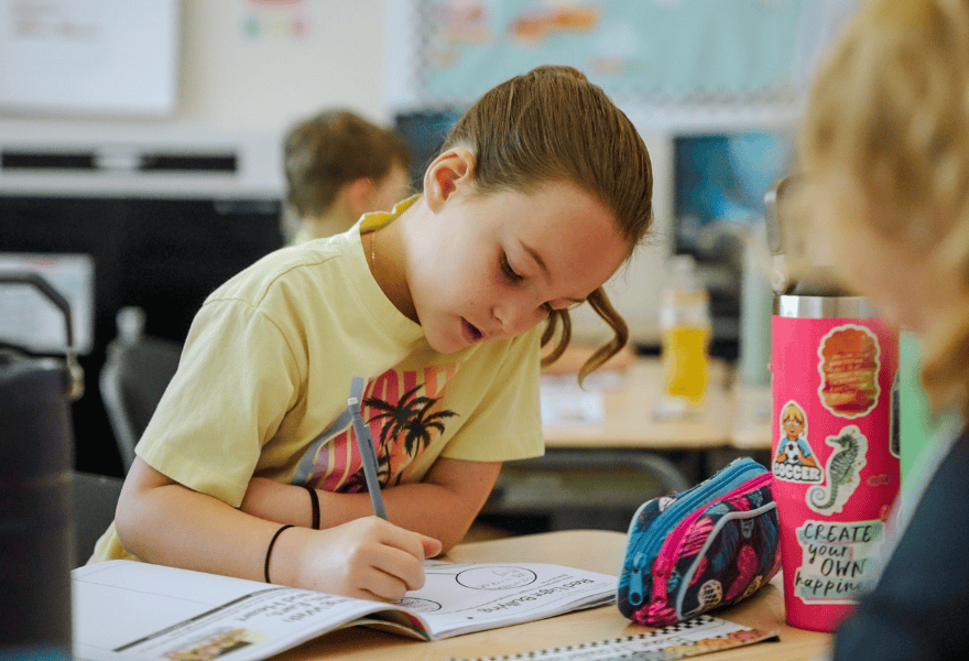 Elementary student completing schoolwork in a classroom, representing education initiatives and youth development programs in Utah communities
