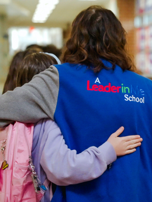 Community volunteer mentoring a student at a local school, supporting youth development and upward mobility through education in Utah