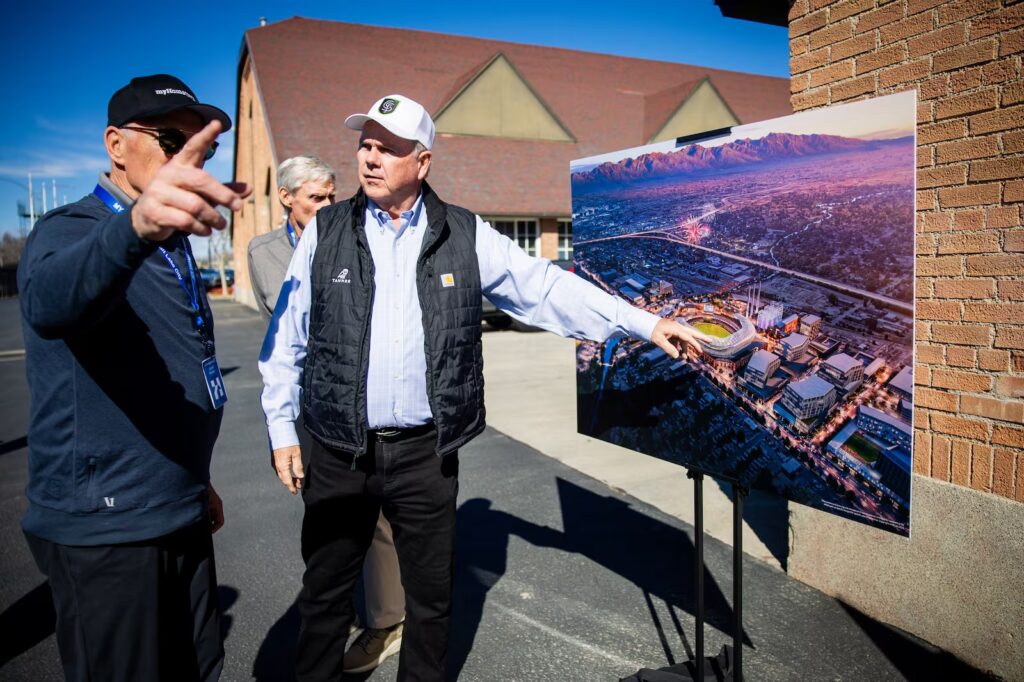 Jared Parker, from myHometown Salt Lake City, left, and Kent Bowman, Cities Strong Foundation board member, right, looks at a rendering before a press conference where community leaders are celebrating the launch of a community-driven plan to revitalize a half-mile stretch of the Jordan River