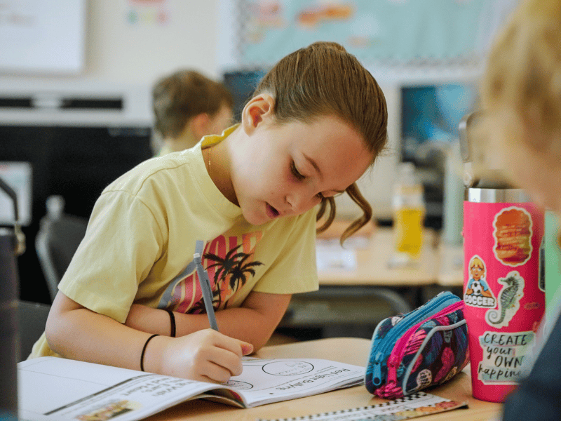 Elementary student completing schoolwork in a classroom, representing education initiatives and youth development programs in Utah communities